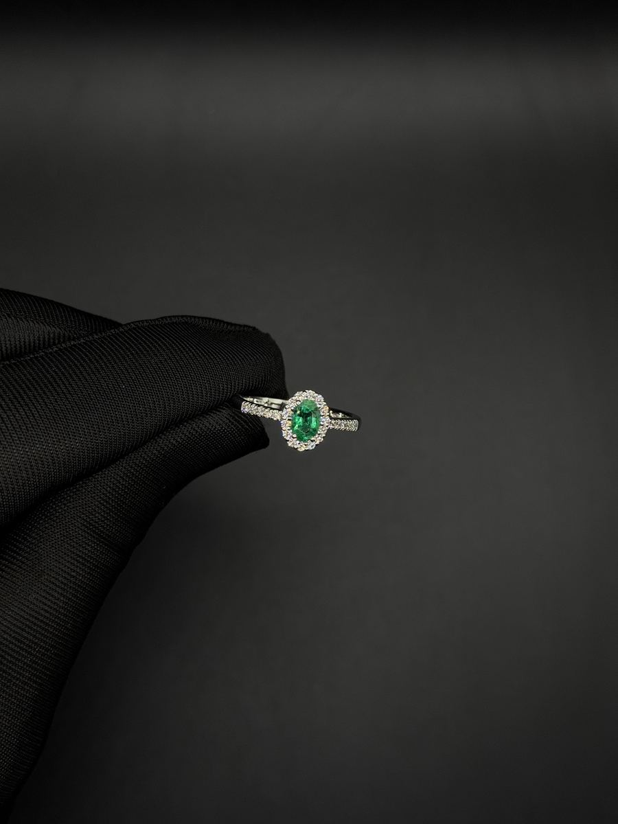 Anello con smeraldo ovale circondato da diamanti